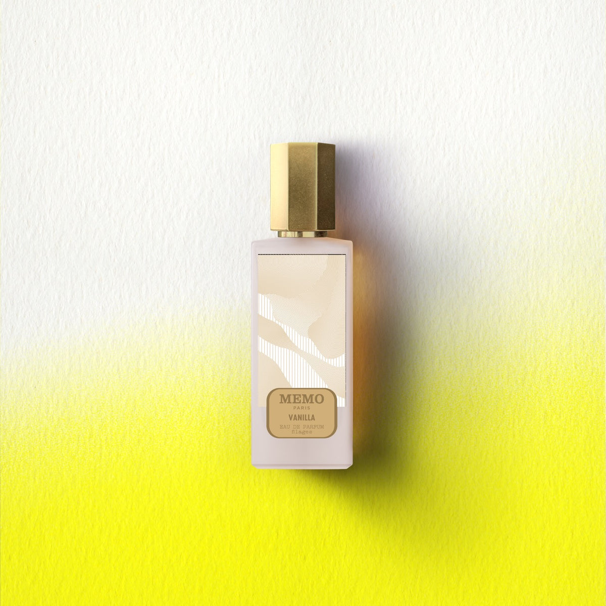 A sleek frosted glass memo paris essences filages vanilla eau de parfum bottle with a polished gold cap